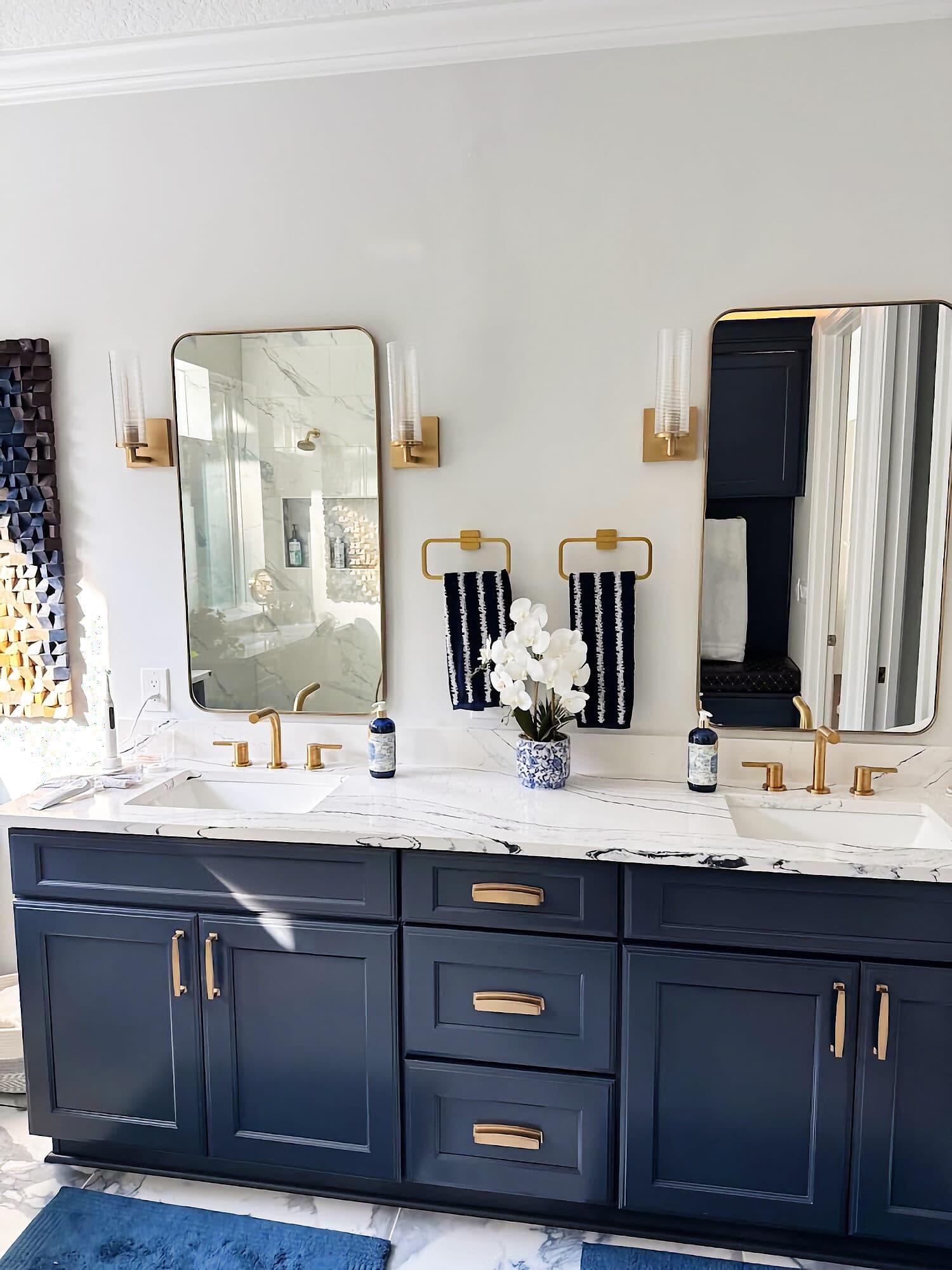 Navy double vanity with marble countertop and gold fixtures in a Coastal Oaks bathroom remodel, Nocatee, Florida